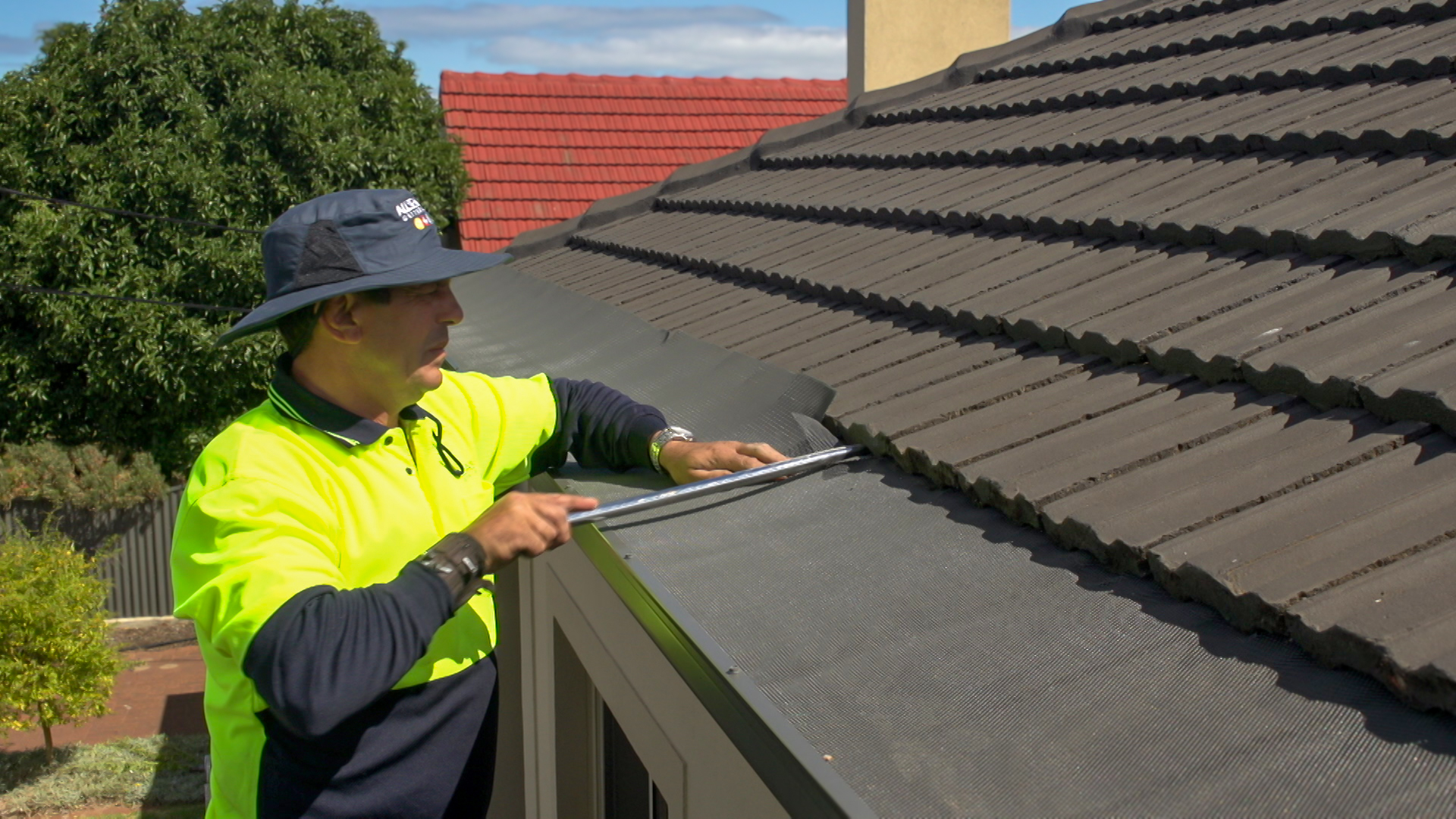 Man installing gutter mesh for effective gutter protection and debris control